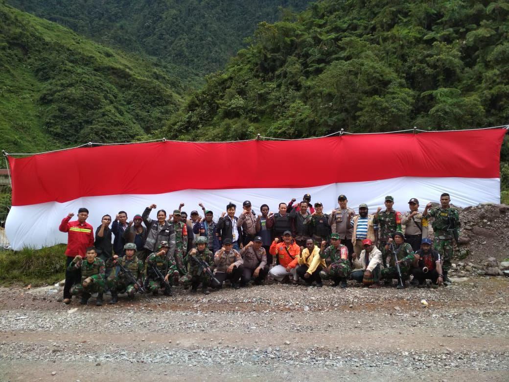 SAMBUT HUT RI KE 73, TNI-POLRI BERSAMA MASYARAKAT KIBARKAN BENDERA MERAH PUTIH BERUKURAN RAKSASA DI DISTRIK TEMBAGAPURA