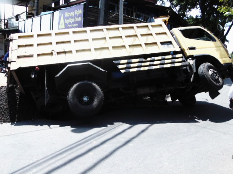 TRUK ANGKUT MATERIAL NYARIS TERBALIK DI DENPASAR BALI