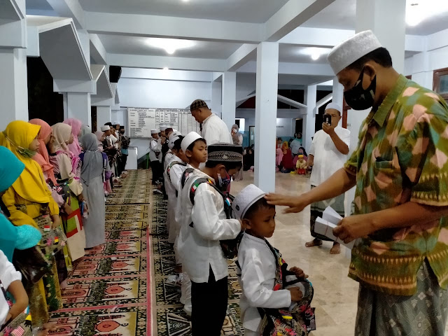 Hari raya anak yatim, puluhan anak berjejer terima santunan di serambi masjid Desa Tambakrejo.